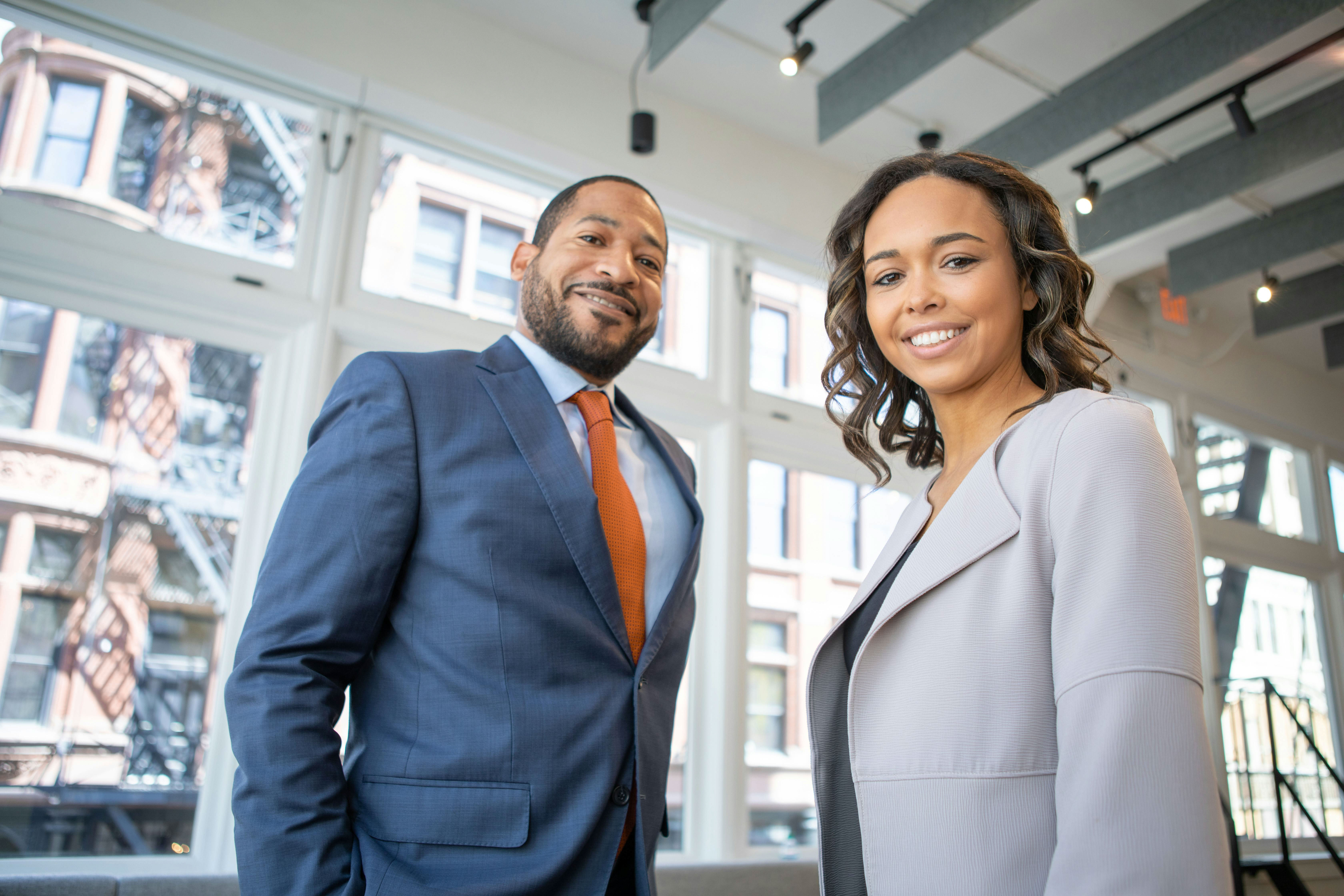 Two business professionals smiling in a modern office, highlighting the value of expert networks in private equity decision-making.
