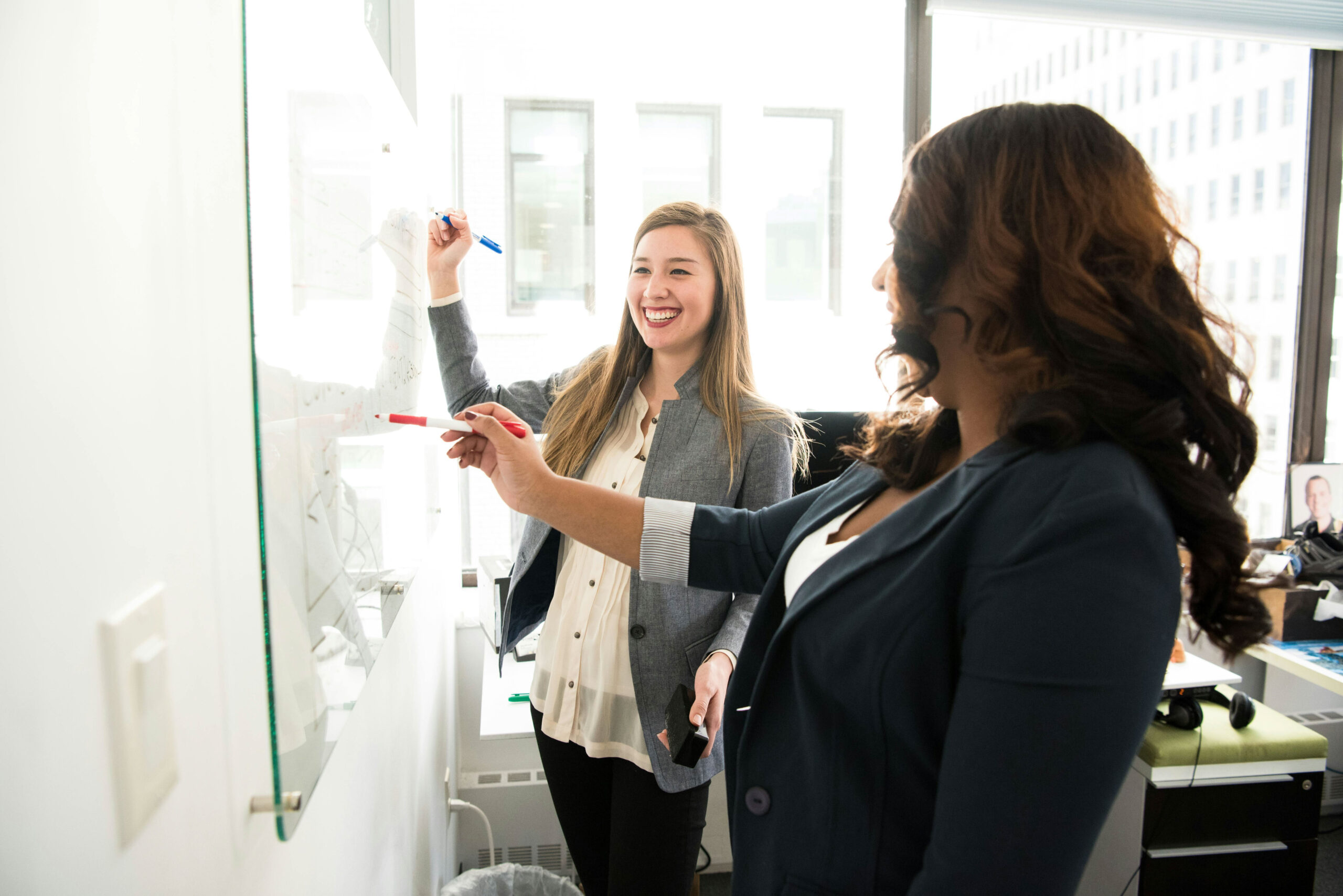 Junior and senior staff members work together at a white board on private equity due diligence process best practices.